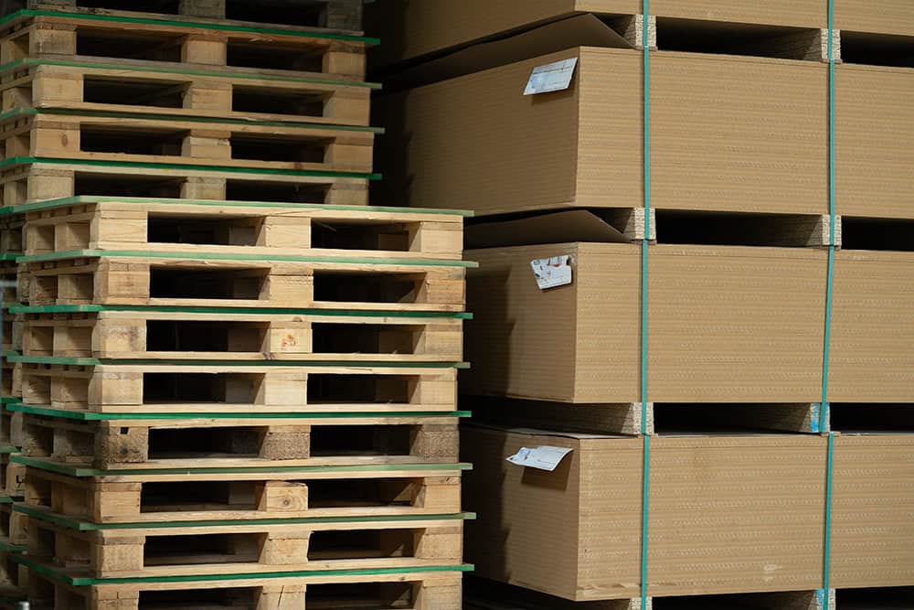 A large stack of pallets in a warehouse. | Unlimited Solutions