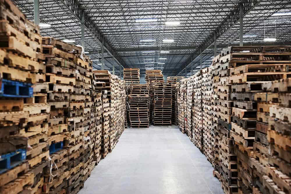 A warehouse with many pallets stacked on top of each other. | Unlimited Solutions