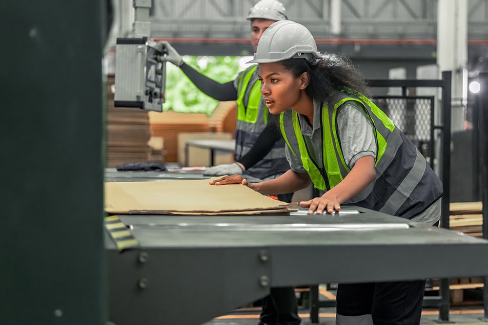 Two workers in safety vests working on a machine. | Unlimited Solutions