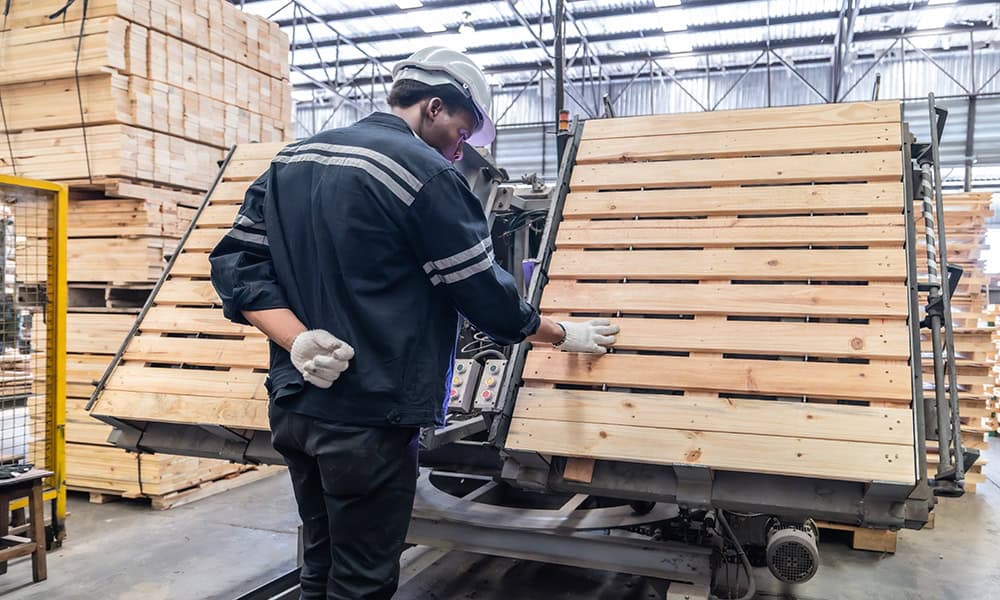 A worker is working on a pallet in a warehouse. | Unlimited Solutions